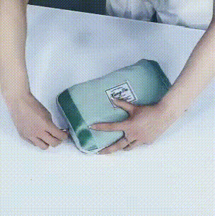 Ein GIF einer Frau, die eine wasserdichte Reisetasche mit großem Fassungsvermögen auseinanderfaltet.