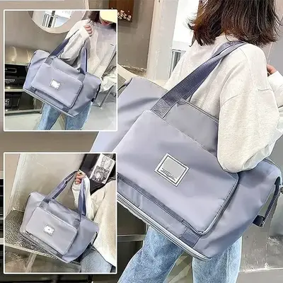 Eine Tasche mit mehreren Fächern und Taschen, die von einer Person mit einem hellen Oberteil getragen wird.